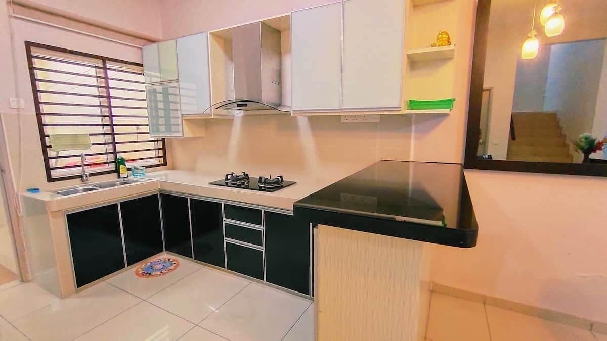 A compact kitchen with a gas stove, a sink, and a window with blinds.