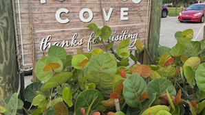 A wooden sign with "TORCASO COVE" and "thanks for visiting" text, surrounded by green foliage. - Charming 2-bedroom townhome in Winter Springs. (Winter Springs)