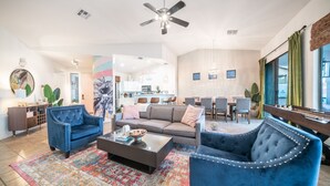 A spacious living room with a sofa, two armchairs, a coffee table, and a dining area with chairs and a table. - Welcome to the Coco Cabana! Located in Estrella Mountain Ranch in Goodyear, AZ! (Goodyear)