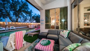 A poolside area with a sofa, chairs, and a dining table. - Welcome to the Coco Cabana! Located in Estrella Mountain Ranch in Goodyear, AZ! (Goodyear)