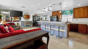 Una cocina moderna con una isla central, taburetes de bar y armarios de madera.