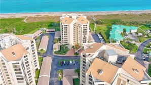 A high-rise hotel complex with multiple buildings, a parking area, and a beach view.