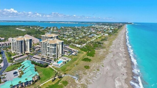 A coastal resort with multiple high-rise buildings, a beach, and a clear view of the ocean.