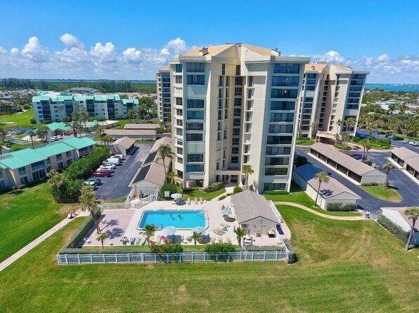 Un hotel de varios pisos con piscina y zona de estar al aire libre.