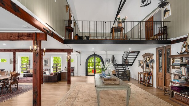 A spacious loft with a high ceiling, a staircase, a dining area, and a library. - THE ULTIMATE RURAL RETREAT Sleeps 13 situated in Berima Southern Highlands NSW (Berrima)