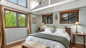 A bedroom with a large bed, two bedside tables, a bench, and a window with curtains. - THE ULTIMATE RURAL RETREAT Sleeps 13 situated in Berima Southern Highlands NSW (Berrima)