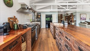 A kitchen with a wooden island, stainless steel appliances, and a view into the dining area. - THE ULTIMATE RURAL RETREAT Sleeps 13 situated in Berima Southern Highlands NSW (Berrima)