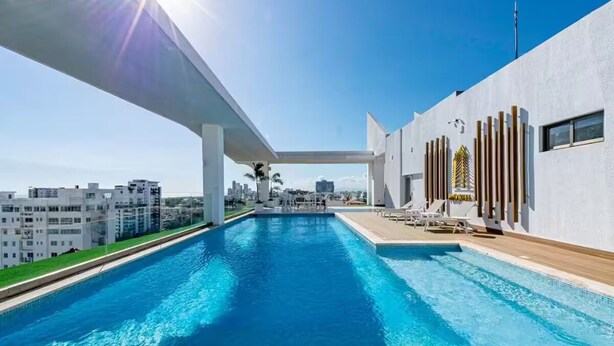A modern swimming pool with a clear view of the city skyline in the background.