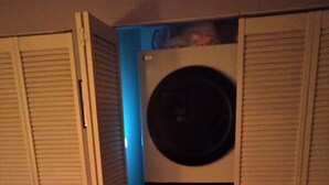 Une petite buanderie équipée d’un lave-linge à chargement frontal, d’un sèche-linge et d’une petite étagère de rangement.