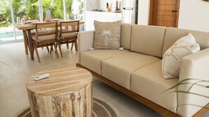 Un salon moderne avec un canapé, une table basse en bois et un coin repas.