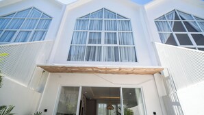 Un bâtiment moderne doté de grandes fenêtres et d’un auvent en bois.