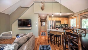 A modern kitchen with a large island, wooden cabinets, and a built-in oven. - Finley Lodge | 5 Mins to Attitash | Game Room (Bartlett)