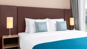 A hotel room with a large bed, two bedside lamps, and a view of the city through the window. - Elegant Palm Retreat w Iconic Sea Marina Vws (Dubai)