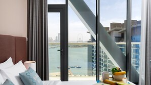 A hotel room with a large window overlooking a cityscape and water. - Elegant Palm Retreat w Iconic Sea Marina Vws (Dubai)