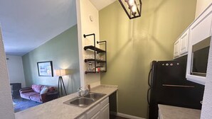 A compact kitchen with a double sink, a refrigerator, and a small countertop.