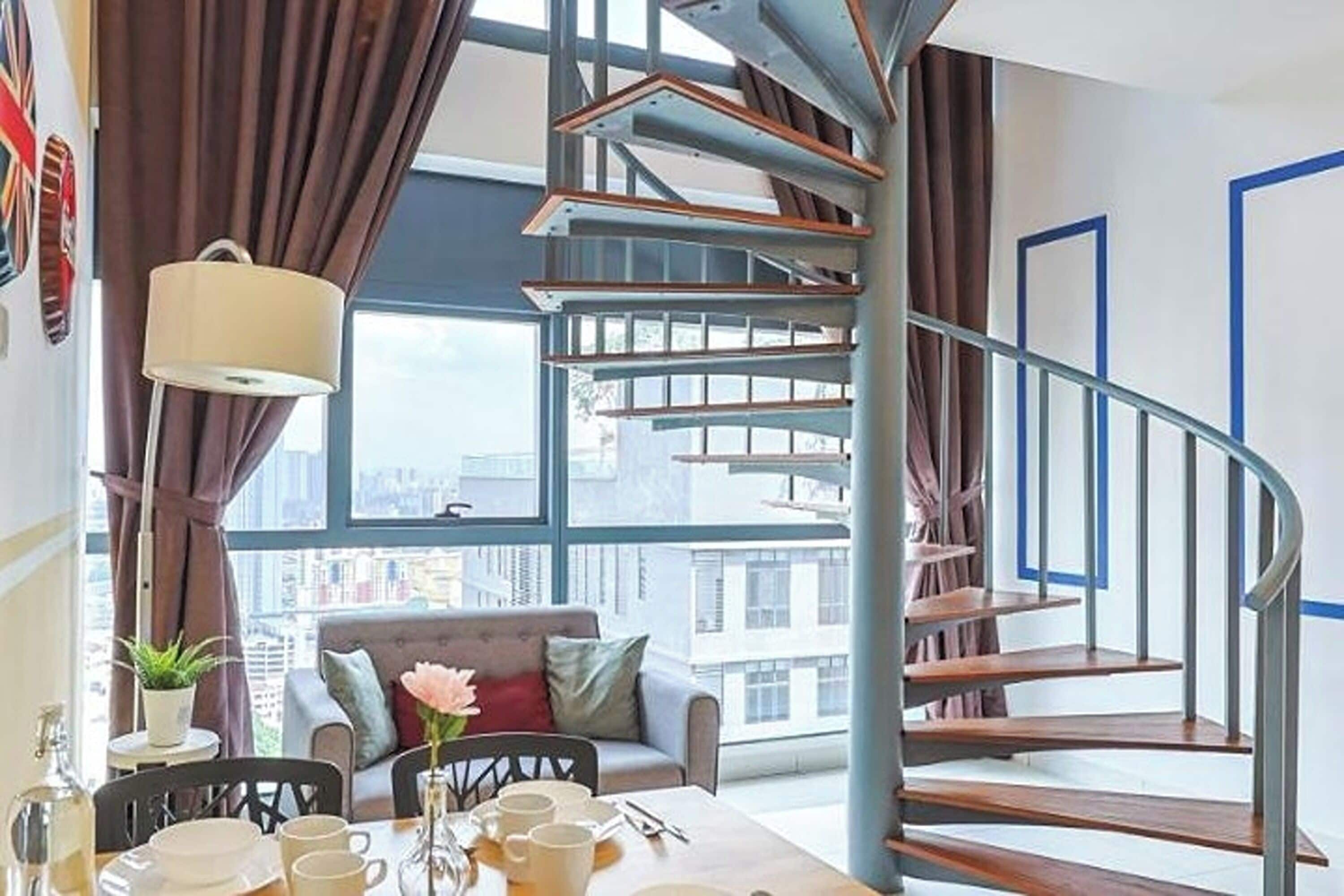 A modern interior with a spiral staircase, a dining area with a table set for two, and a sofa.