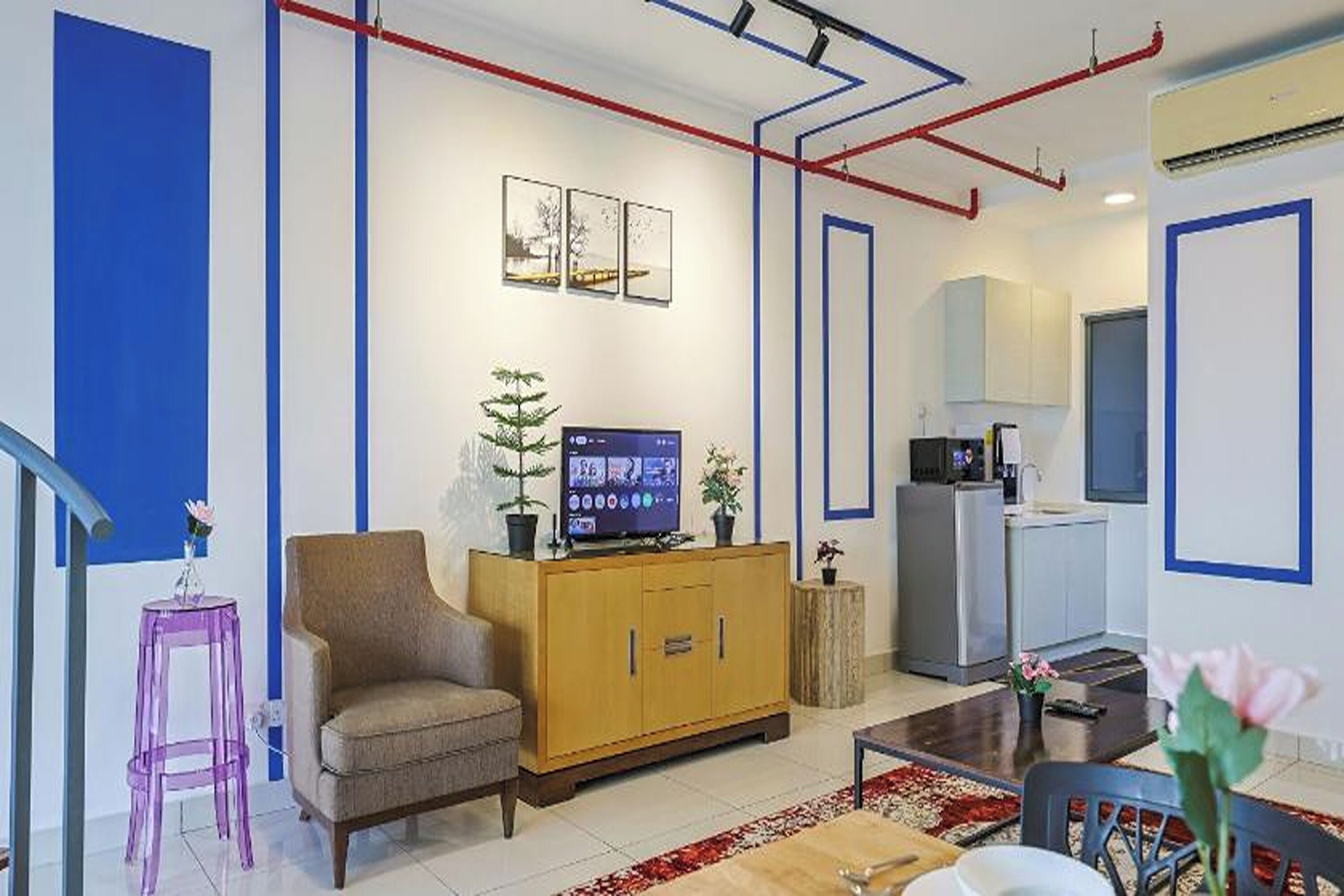 A modern living room with a sofa, TV, and a small dining table.