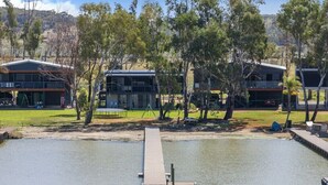 A lakeside property with modern buildings, a dock, and a grassy area with trees. - Absolute Waterfront Bliss – Pet Friendly, Seperate living areas, Family Shack. (Pellaring Flat)