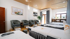 A spa room with four massage beds, grey armchairs, a wooden ceiling, and a large window. - Danang private pool villa by Esea43 (Da Nang)
