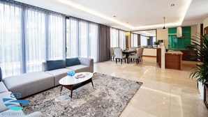 A modern living room with a sofa, coffee table, and dining area. - Danang private pool villa by Esea43 (Da Nang)