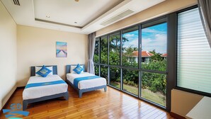 A hotel room with two beds, large windows, and a view of greenery. - Danang private pool villa by Esea43 (Da Nang)