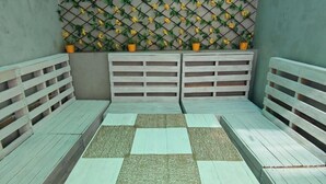 A seating area with a checkered floor and a lattice wall decorated with yellow flowers. - Cuba linda  (Asunción)