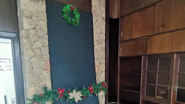 A lobby with a stone fireplace, a clock, and a glass coffee table with a card. - Cuba linda  (Asunción)