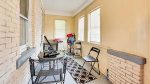 A narrow corridor with a glass table and chairs, a fan, and a patterned rug. - Convenient Hartford Condo < 2 Mi to Dtwn! (Hartford)