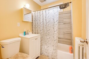 A bathroom with a toilet, sink, and shower area.