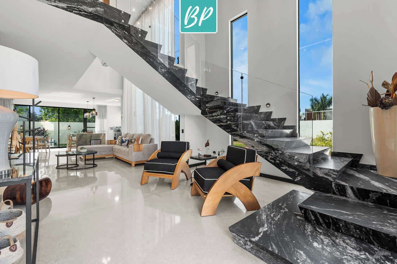 A modern interior with a staircase, seating area, and large windows.