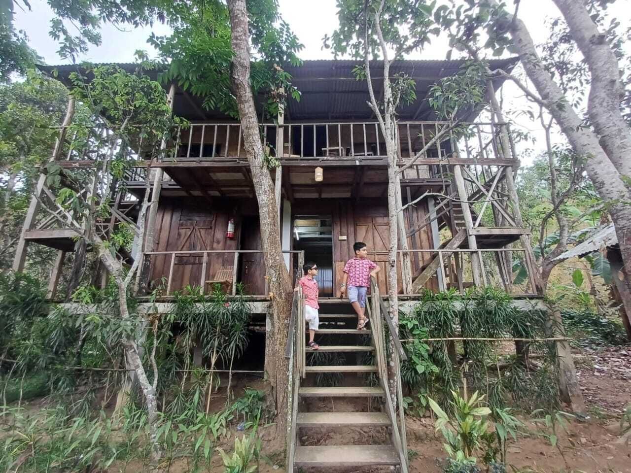 Une maison en bois avec un escalier menant à un balcon.