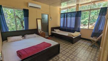 Quarto com duas camas, um espelho e uma janela com cortinas.