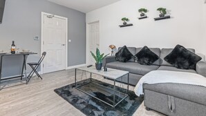 A modern living room with a grey sofa, black cushions, a coffee table, and a small plant. - Central Location • Edgbaston Village / Broadway Plaza | Fast Wi-Fi | Sleeps 4 (Birmingham)