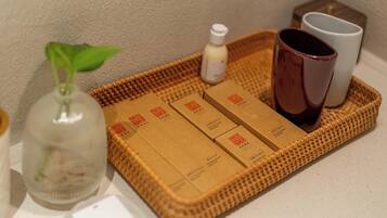 A tray with toiletries, a potted plant, and two cups.