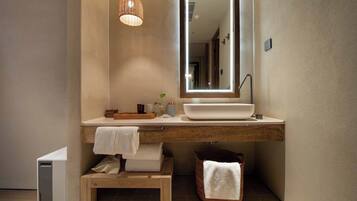 A modern bathroom with a large mirror, a vessel sink, and a wooden vanity.