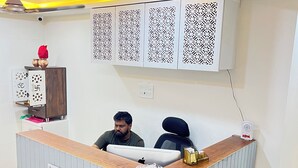 Un mostrador de recepción con un cartel que dice "XF Reception", una computadora y un ventilador sobre el mostrador.