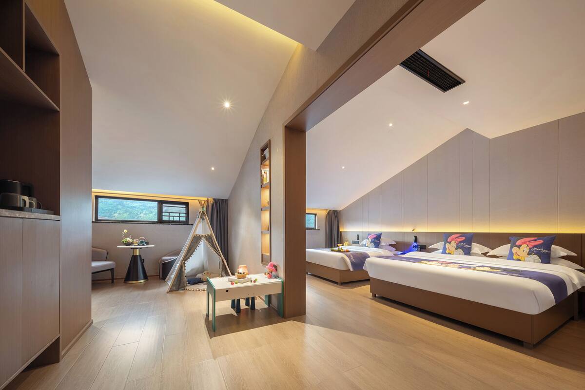 Habitación de hotel moderna con una cama grande, un escritorio y vistas al exterior.