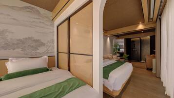 Une chambre d’hôtel avec deux lits, une grande peinture murale et une porte coulissante donnant sur une salle de bain.