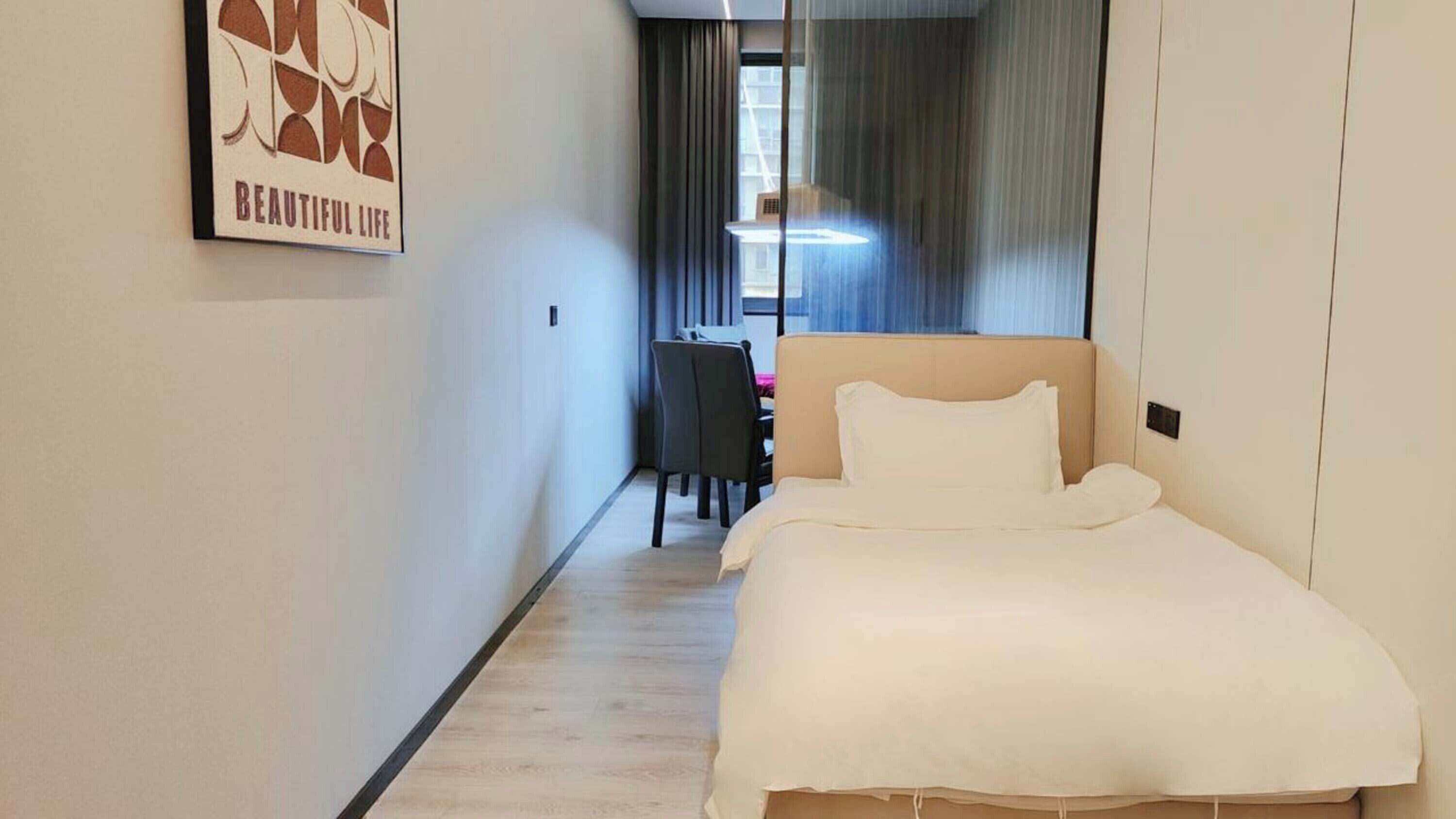 Una habitación de hotel con una cama, un escritorio y una silla.