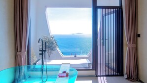 A balcony with a glass table, a showerhead, and a view of the sea. - Yasong Jianwen Resort Hotel (Qingdao)