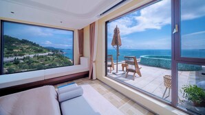 A spacious balcony with a view of the sea and a pool, a comfortable seating area, and a large window with curtains. - Yasong Jianwen Resort Hotel (Qingdao)