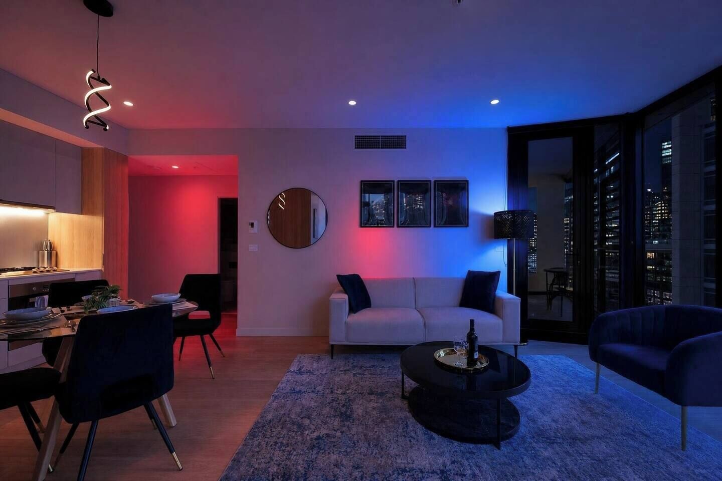 A modern living room with a dining area, a sofa, a coffee table, and a city view through large windows.