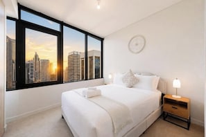A bedroom with a large window, a bed, bedside lamps, and a wall clock. - Sydney Luxe Observatory Home | City, Pool & Gym (Sydney)