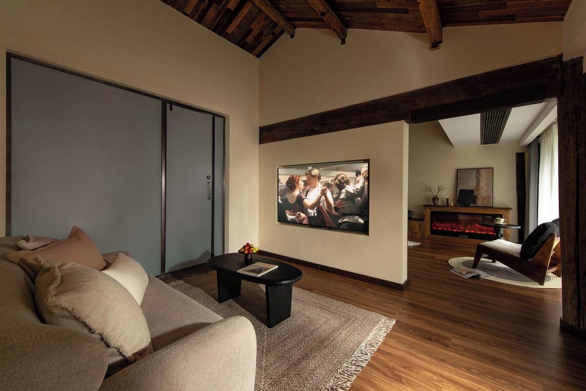 A modern living room with a sofa, a coffee table, and a fireplace.