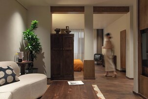 Una sala de estar moderna con un sofá, una mesa de centro, un aparador y una planta.