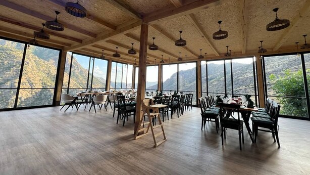 A spacious dining area with high ceilings and large windows offering mountain views.