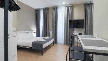 Ein modernes Hotelzimmer mit Bett, Schreibtisch und Fernseher.