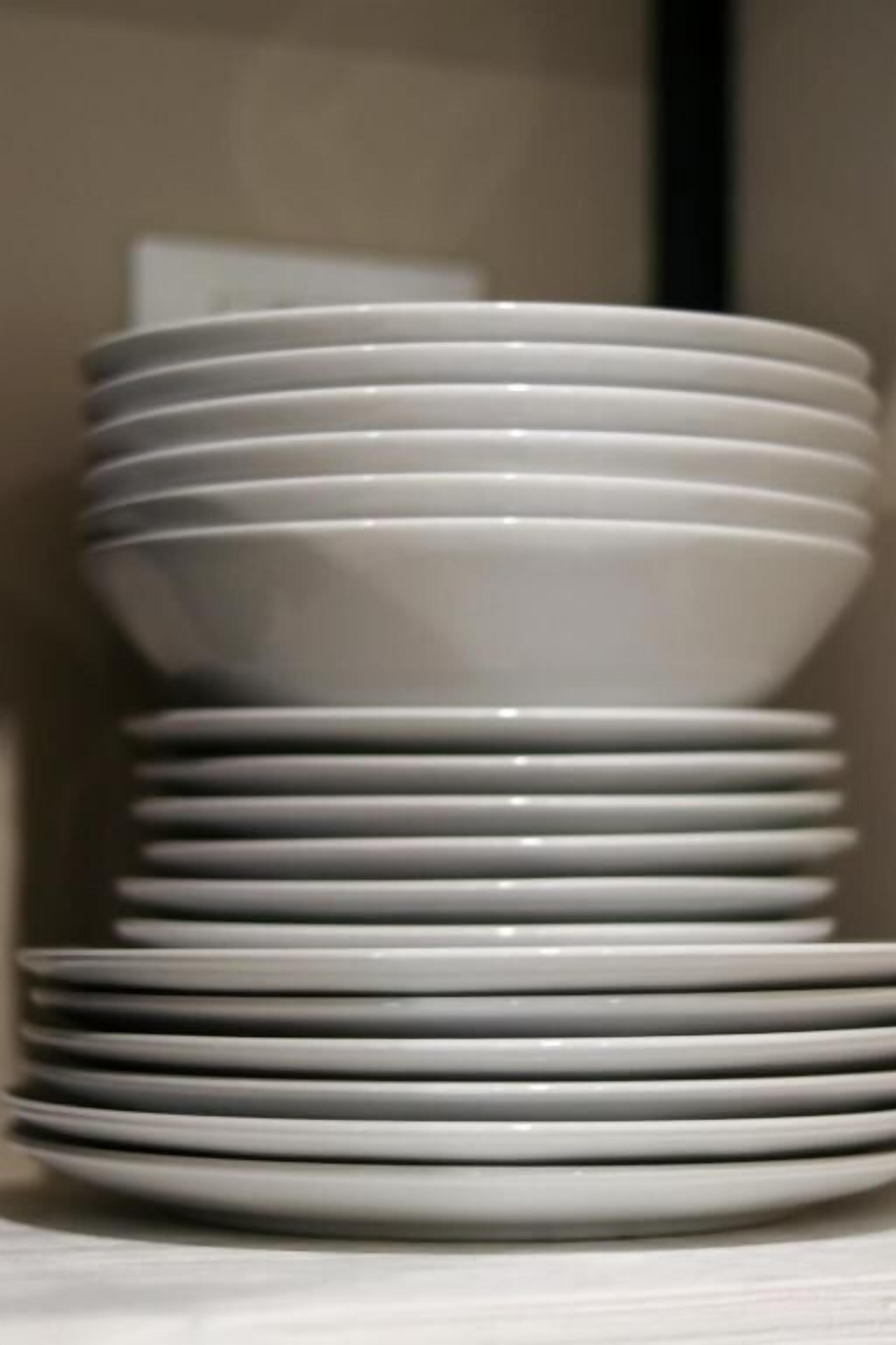 Une pile d’assiettes blanches sur une table.