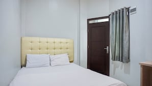 A bedroom with a bed, a wooden door, and a curtain. - Hotel O Banda Aceh near UIN formerly Alif Guest House Syariah (Banda Aceh)