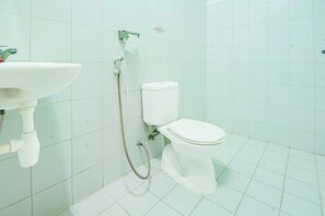 A bathroom with a white sink, toilet, and shower.